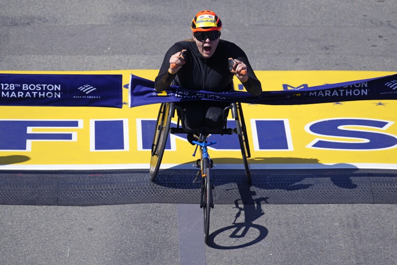 Wheelchair athlete Eden Rainbow-Cooper cheers as she crosses the finish line of the Boston Marathon.